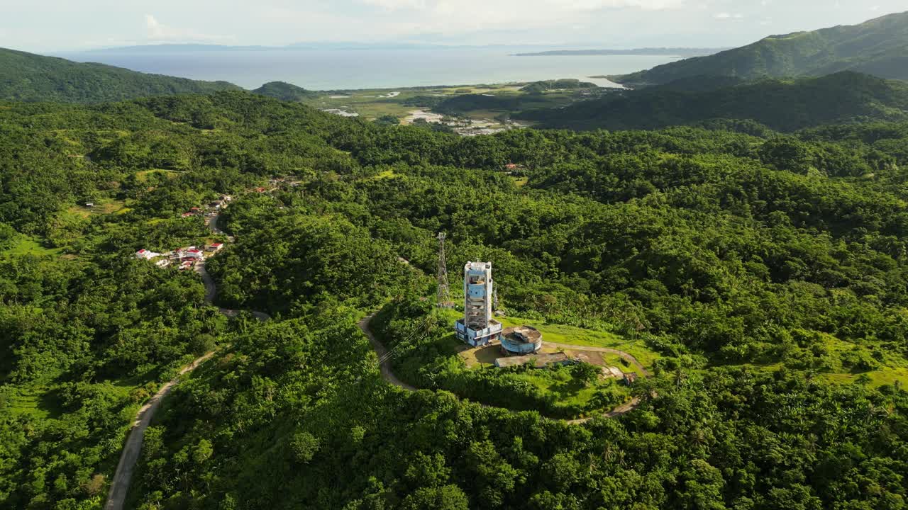 Panoramic view of weather forecast Doppler radar station atop lush tropical island setting Catanduanes, Philippines - aerial forward shot
