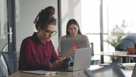 Mujer-De-Negocios-Que-Usa-Un-Teléfono-Inteligente-Durante-La-Jornada-Laboral-En-La-Oficina