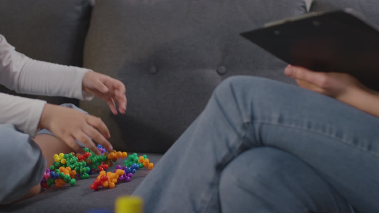 집에서 여성 교사나 교육 심리학자의 도움을 받거나 평가를 받는 asd 스펙트럼의 소녀 클로즈업