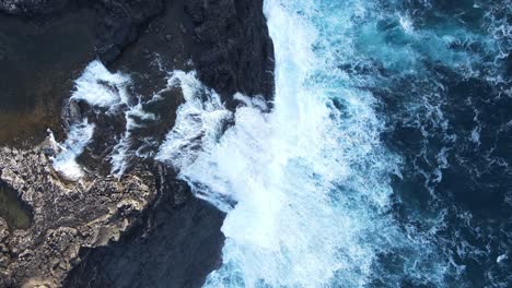 Rising-top-down-drone-footage-of-the-Bøsdalafossur-Waterfall-near-the-Leitisvatn-Lake,-aka-the-Floating-Lake,-on-the-Vagar-island-in-the-Faroe-Islands