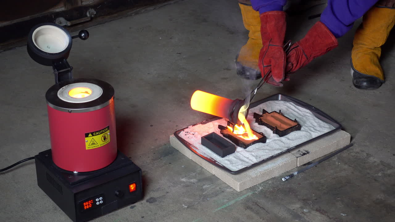 White-hot crucible is removed from furnace and molten metal poured into molds, then crucible replaced in furnace