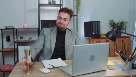 businessman make video call conversation on laptop celebrate successful contract drinking champagne