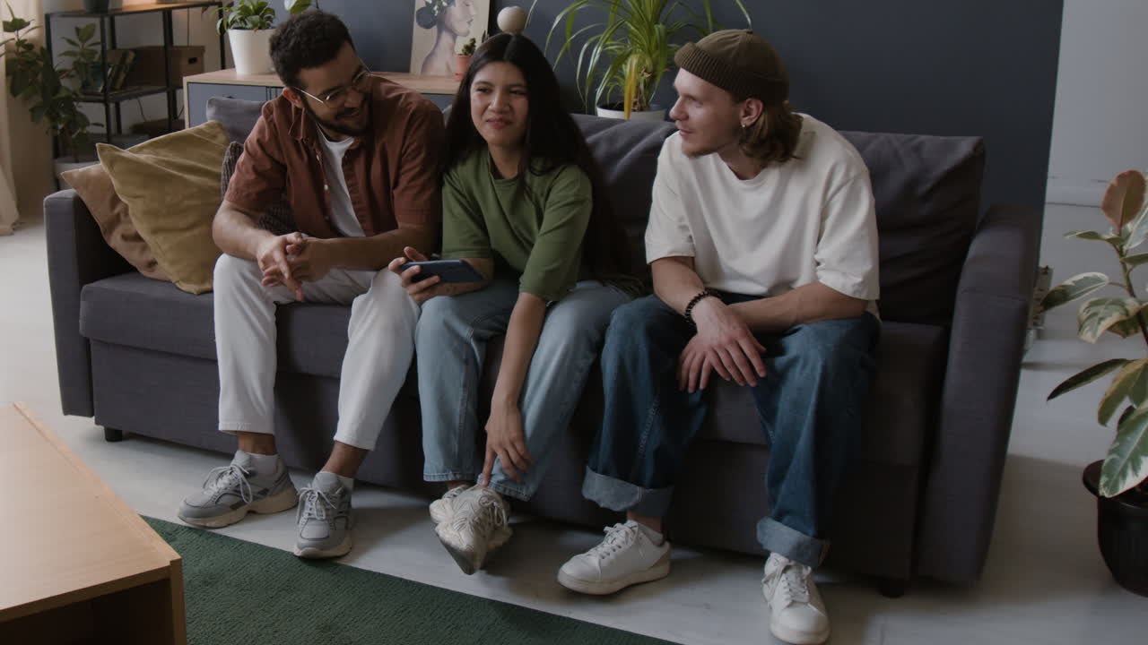 A group of friends having a casual conversation on a couch in a living room