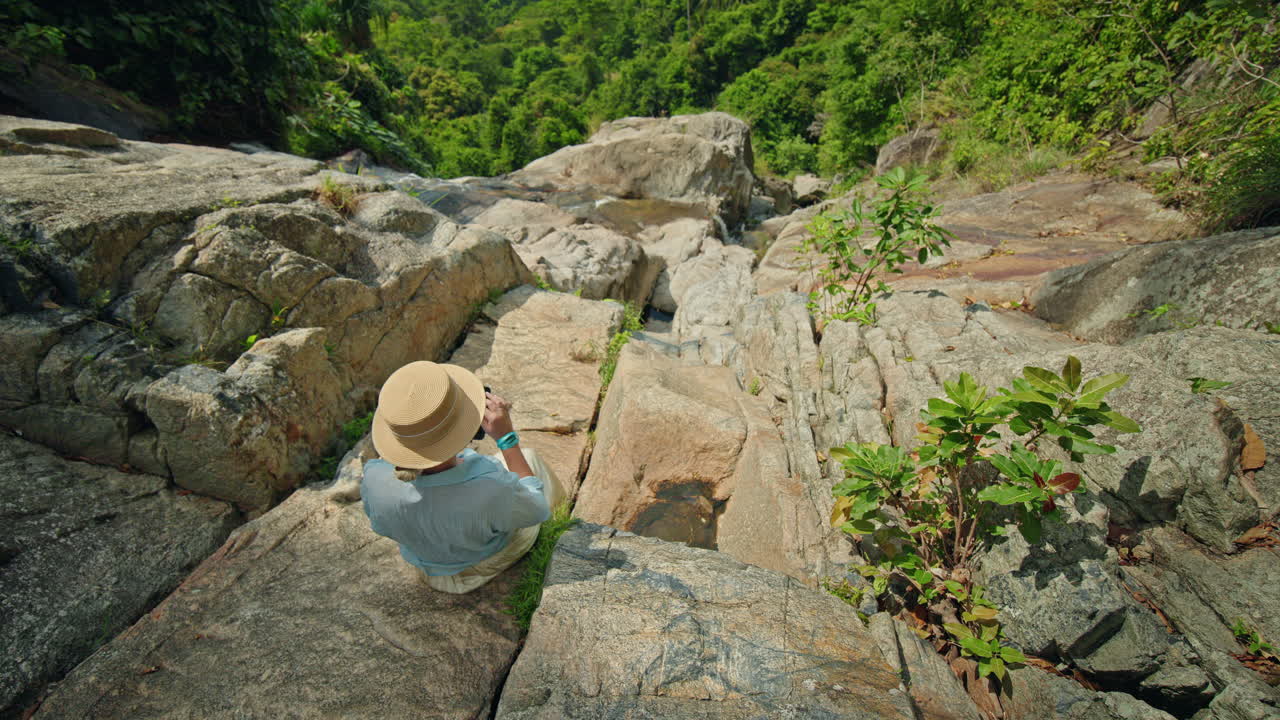 Seorang wanita menikmati pemandangan di air terjun