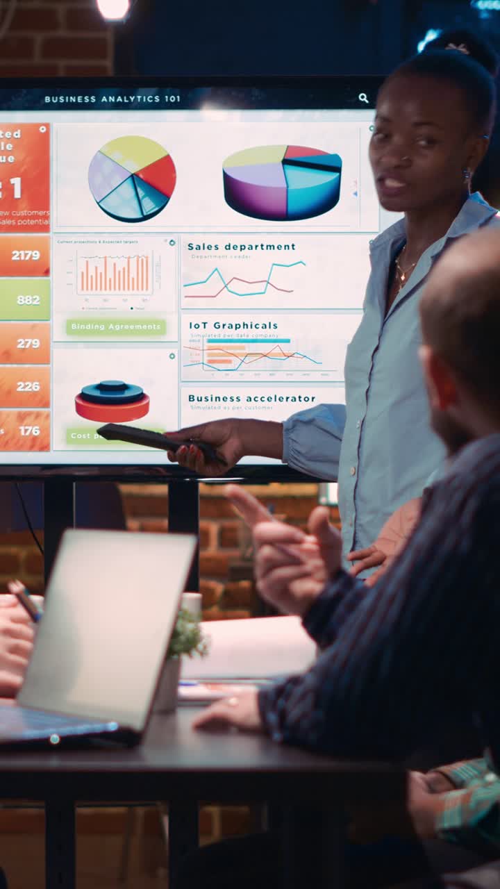 Vertical video: African american business coach giving analytics presentation in meeting