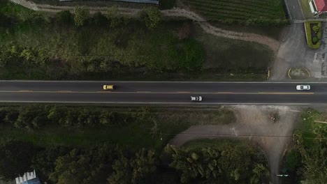 Drohnenaufnahme-Aus-Der-Luft:-Der-Verkehr-Auf-Einer-Von-Natur-Umgebenen-Fahrbahn-Am-Stadtrand