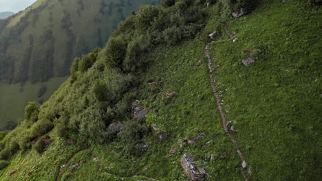 Filmische-Luftaufnahme-Eines-Einsamen-Wanderers,-Der-Bei-Sonnenaufgang-Den-Bergweg-Entlang-Geht