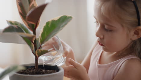 petite fille arrosant la plante à la maison donnant de l'eau nourrissant la croissance enfant jouissant de la responsabilité pour la nature 4k