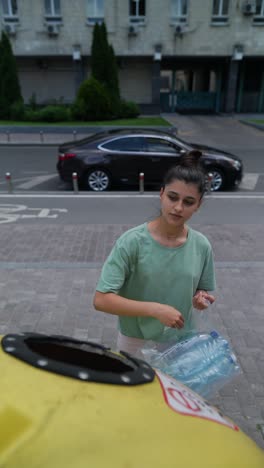 woman recycling plastic bottles in city street