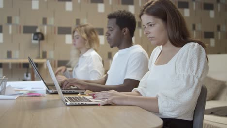 fila de gerentes serios y enfocados sentados a la mesa