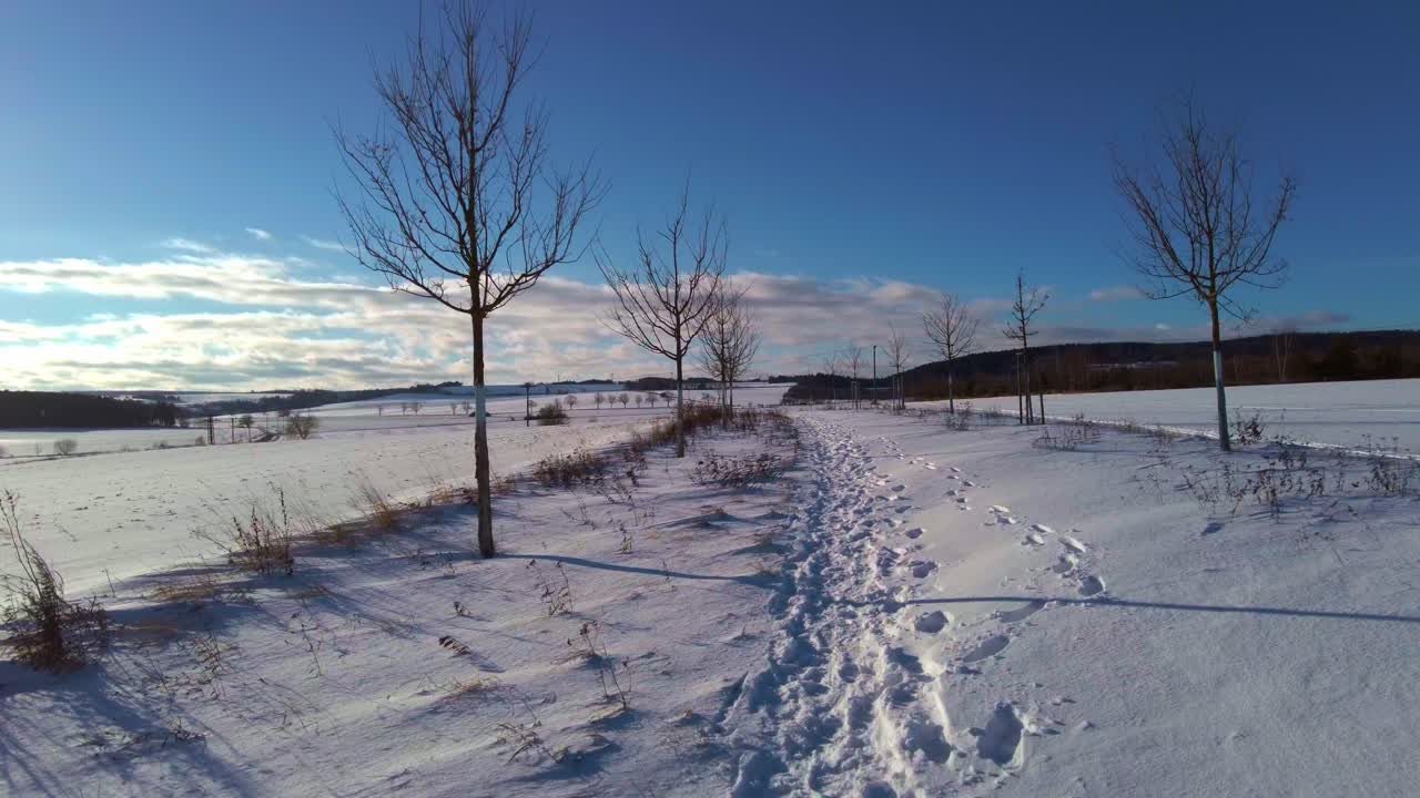 Walking through a snowy alley in winter on a sunny day - view from the first person