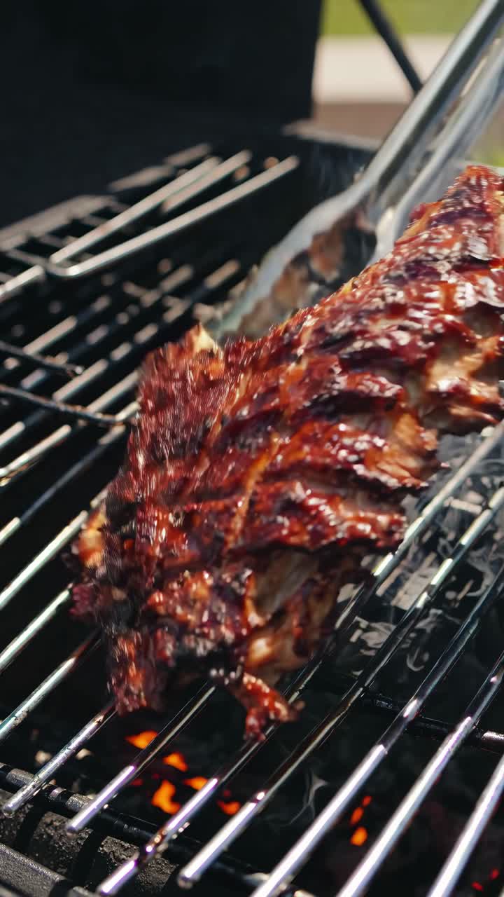 Primo piano angolato di costine sfrigolanti su una griglia, che cattura l'essenza affumicata e la consistenza succulenta.
