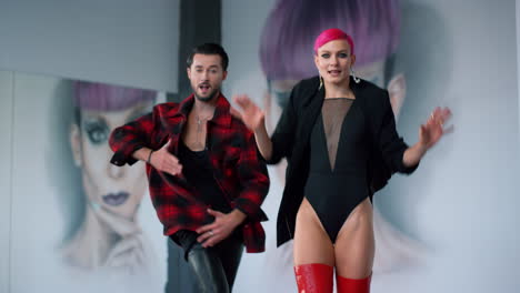 cheerful couple moving hands while dance indoors. dancers rehearsing in studio.