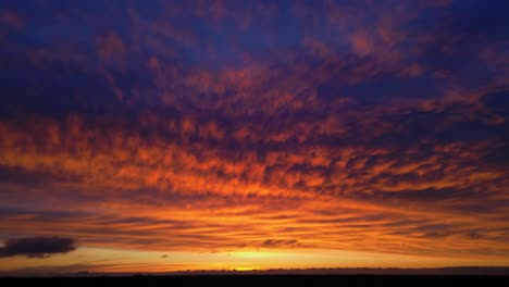 hermosa calma naranja púrpura rosa azul puesta de sol aérea con nubes cumulus