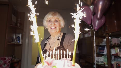 mulher sênior feliz segurando bolo. celebrando aniversário de aniversário em casa