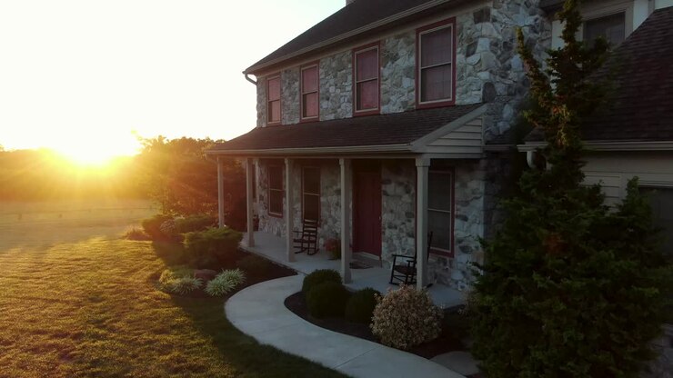 Rising aerial of front of traditional stone house