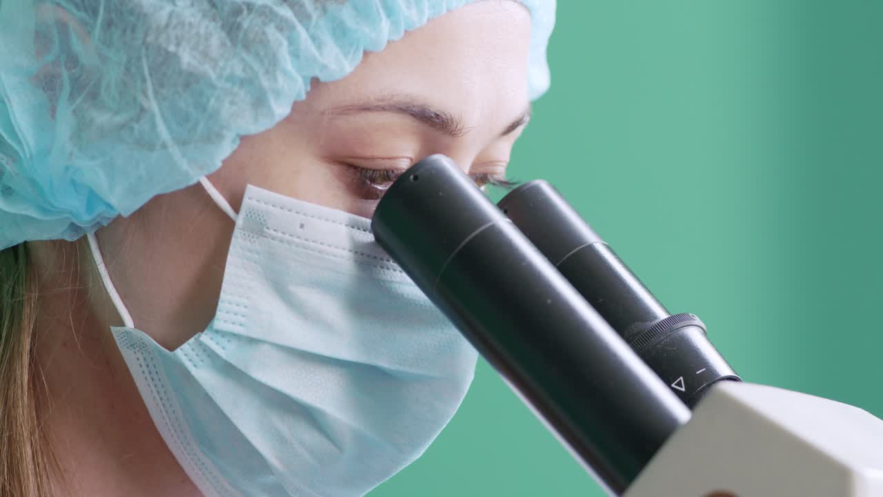 실험실 에서 현미경 을 사용하는 과학자