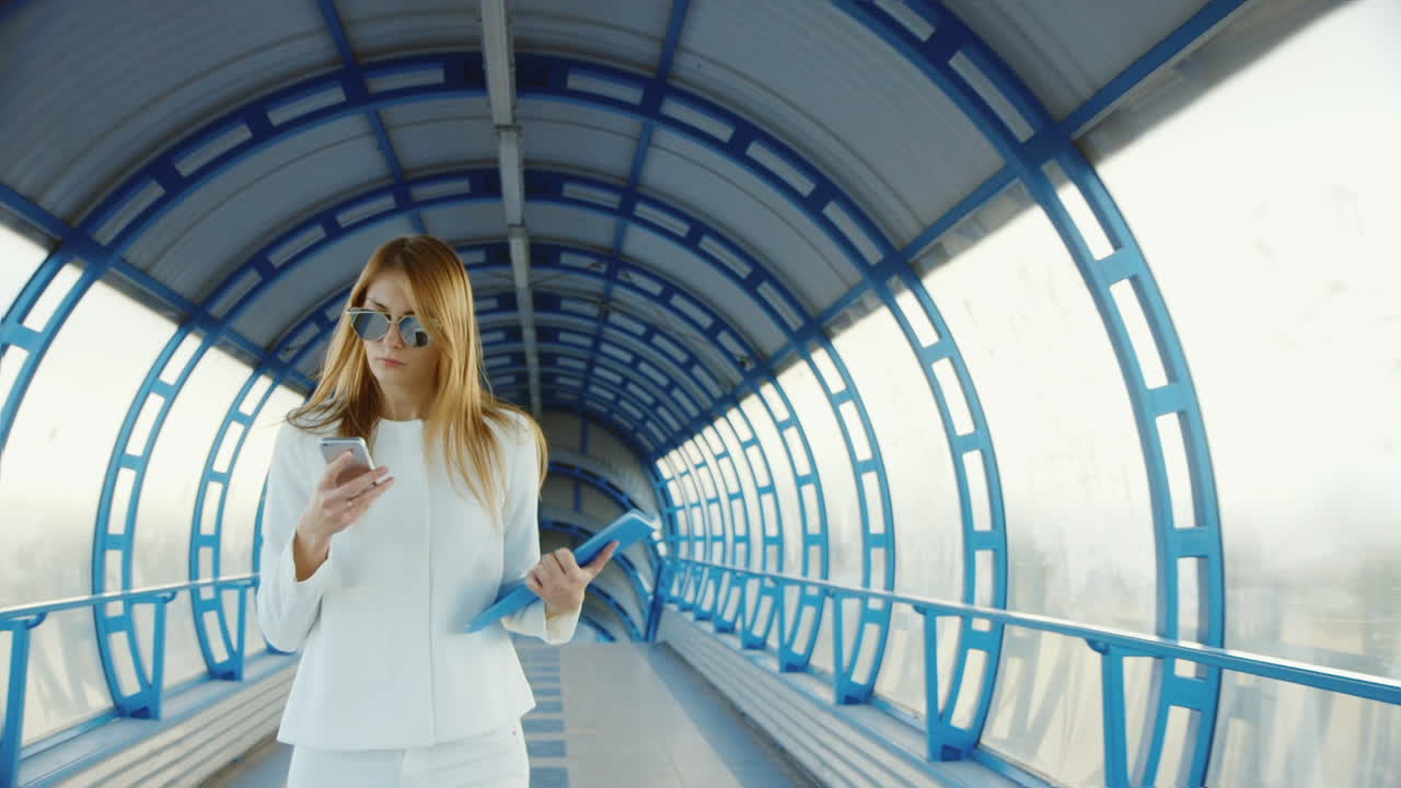 mujer de negocios con traje hablando sobre la transición moderna sosteniendo una carpeta con documentos y teléfono