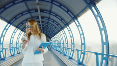 mujer de negocios con traje hablando sobre la transición moderna sosteniendo una carpeta con documentos y teléfono