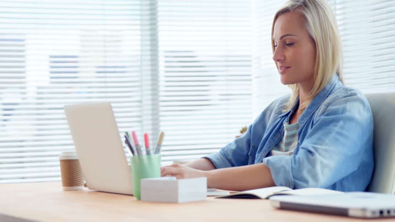 mujer de negocios trabajando en una computadora portátil en su escritorio