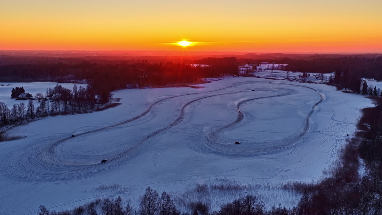 Cars Driving And Drifting On The Ice Racing Track At Dusk On The Frozen Lake. - aerial shot