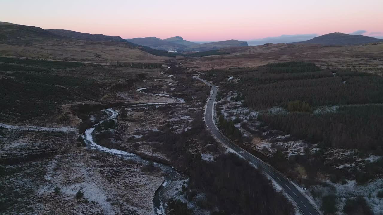 los tonos del crepúsculo sobre la isla de skye con un camino sinuoso y un paisaje helado, vista aérea