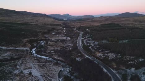 Tonos-Crepusculares-Sobre-La-Isla-De-Skye-Con-Un-Camino-Sinuoso-Y-Un-Paisaje-Helado,-Vista-Aérea