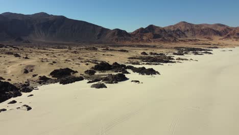 Shades-of-gold-in-mountain-desert-landscape-aerial,-sand-and-rock