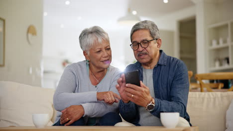 Mature,-man-and-woman-with-smartphone-in-home