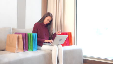 woman type in credit card number on the laptop