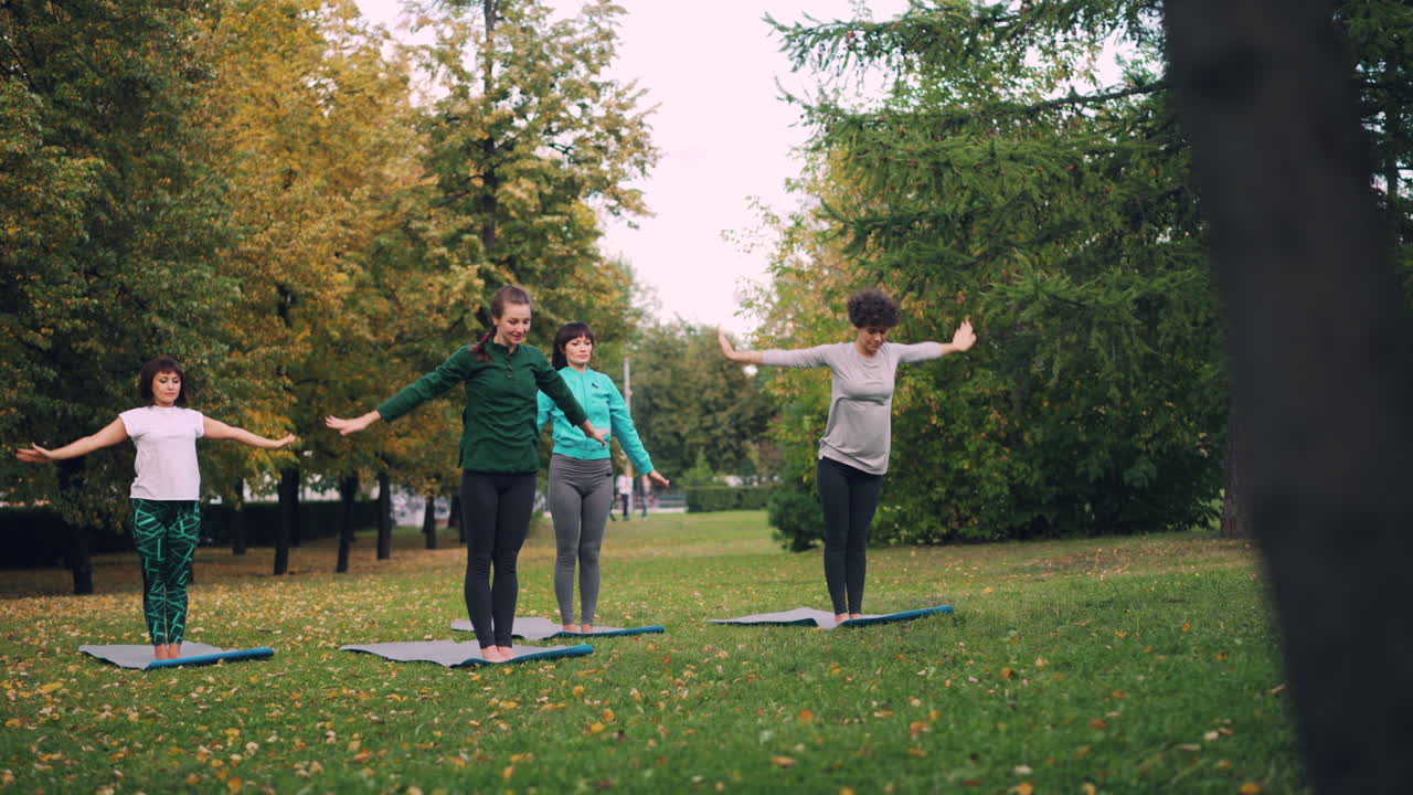 Women practicing yoga in an autumn park