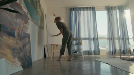 woman artist painting in a cozy home studio with city views