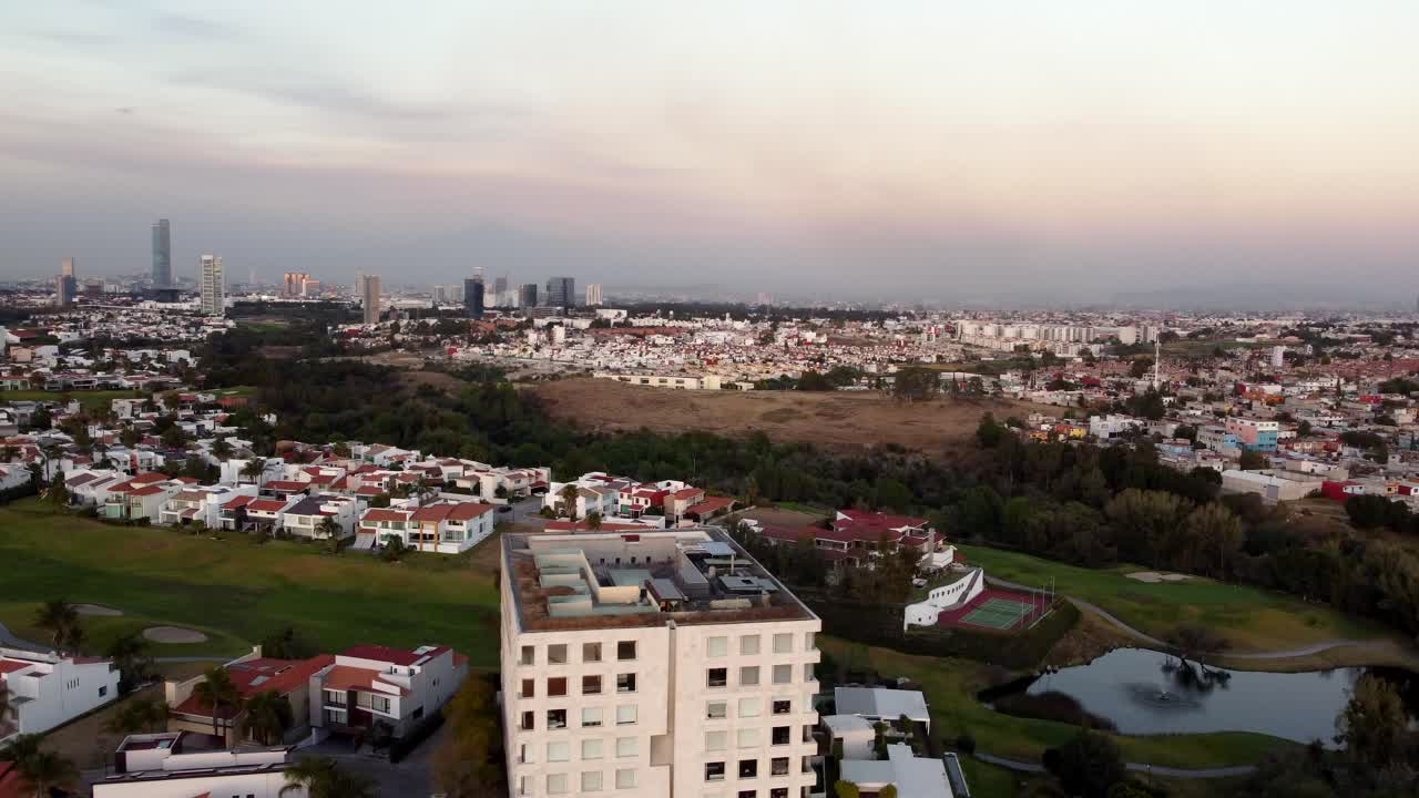 hoteles y casas suburbanas al lado del campo de golf en la ciudad de puebla al atardecer