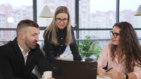 people are busy with the discussion. colleagues sitting at desk, looking at papers and discussing them. cheerful teammates at work.