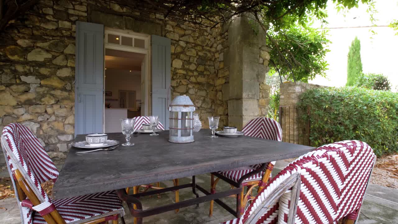 Slow orbiting shot of a set garden table outside of a villa in France