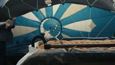 foco de rack desde la cesta del globo de aire caliente hasta el interior del globo de aire caliente mientras el ventilador infla el globo en el suelo al amanecer en la fría mañana de invierno