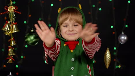 Girl-in-Christmas-elf-Santa-helper-costume-waving-greeting-with-hand.-Hello,-hi,-greetings-gesture