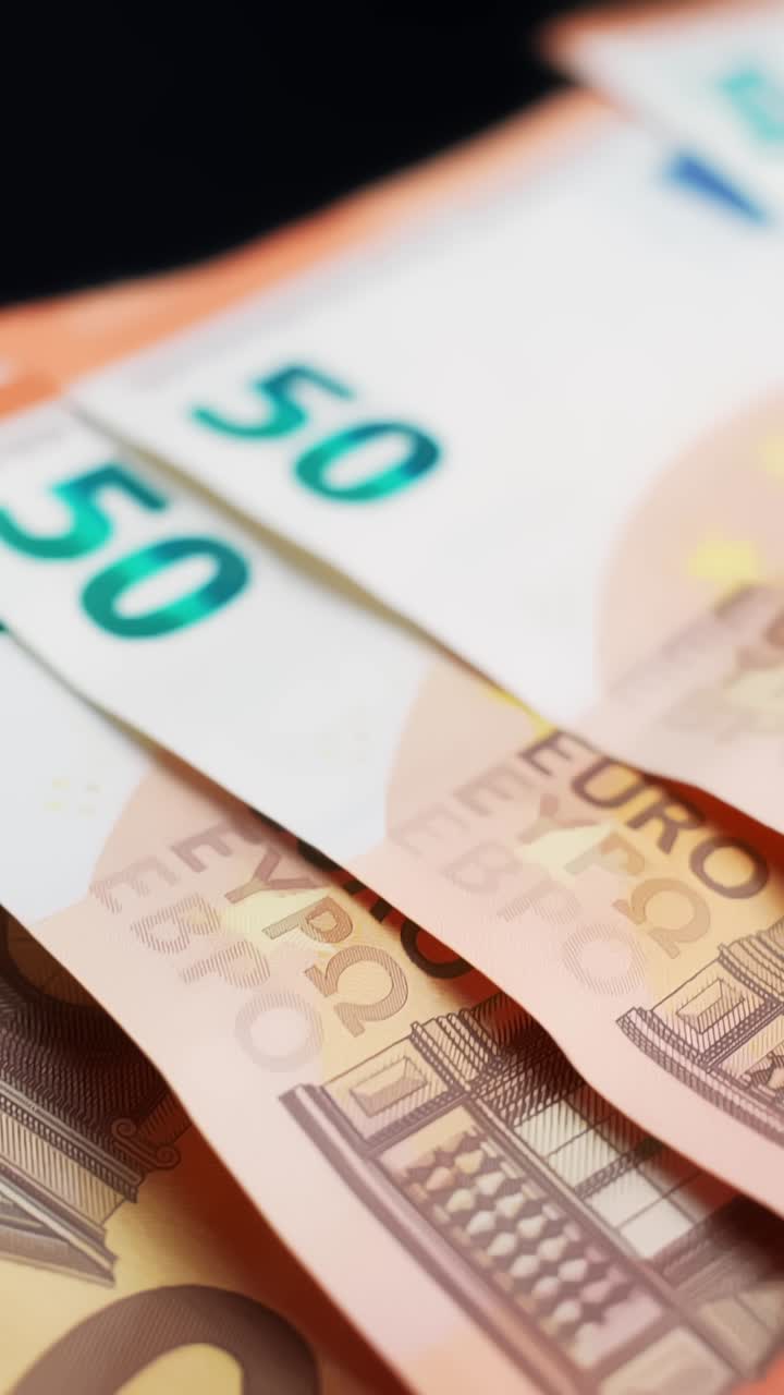 Vertikale Makro-Nahaufnahme von überlappenden 50-Euro-Banknoten mit geringer Schärfentiefe und Bokeh, perfekt als sauberer Finanzhintergrund für Bankwesen, Inflation, Ersparnisse und Zahlungen.
