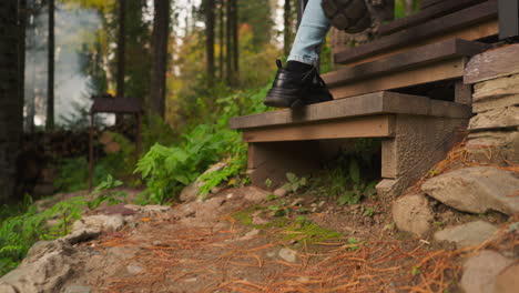 woman steps on stairs leading to cottage. young woman returns from walk in forest alone. forest embraces with symphony of natural sounds