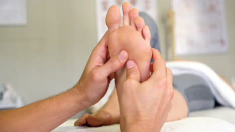 physiotherapist giving foot massage to a woman