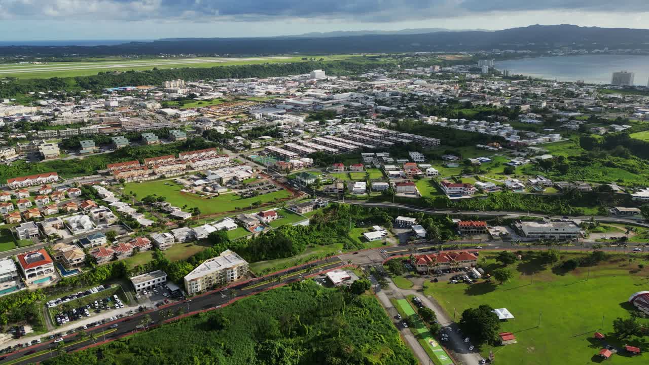 Aerial overview of buildings and residential homes along highway roads at Tamuning, Guam, during daytime