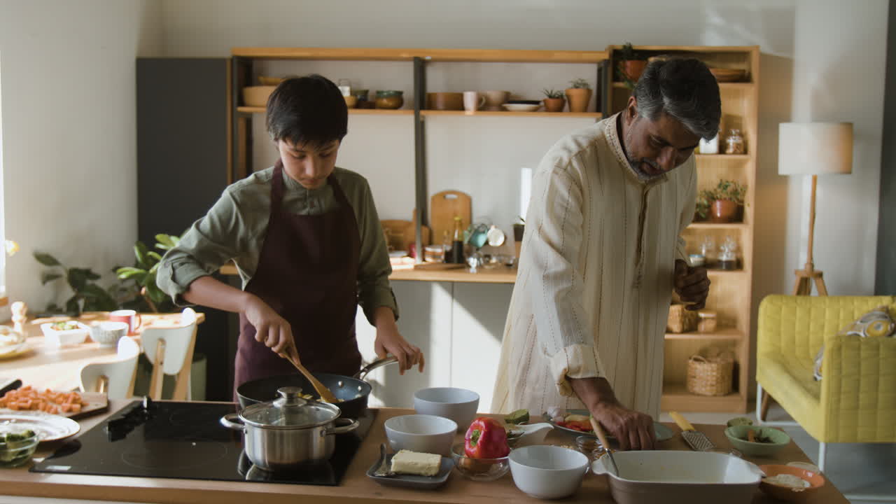 Father and son cooking together in a modern kitchen