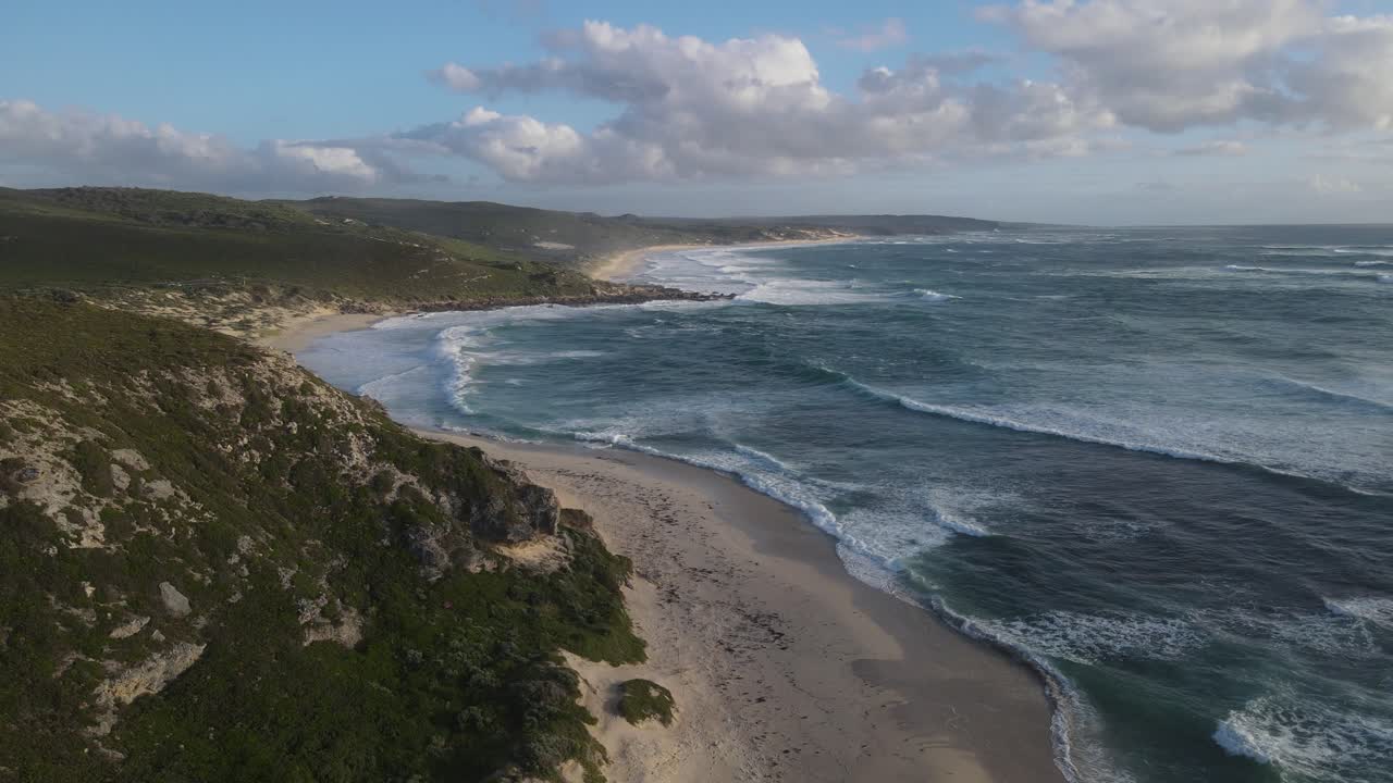 vuelo aéreo a lo largo de una idílica playa vacía y olas rompiendo contra la costa durante una pandemia