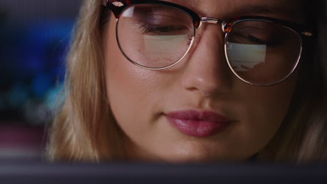 retrato en primer plano hermosa mujer de negocios caucásica trabajando hasta tarde usando una tableta navegando por datos de gráficos financieros mirando la información en la pantalla usando gafas