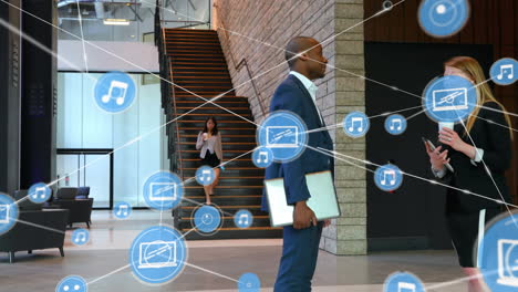 Network of digital icons over diverse businessman and businesswoman talking to each other at office
