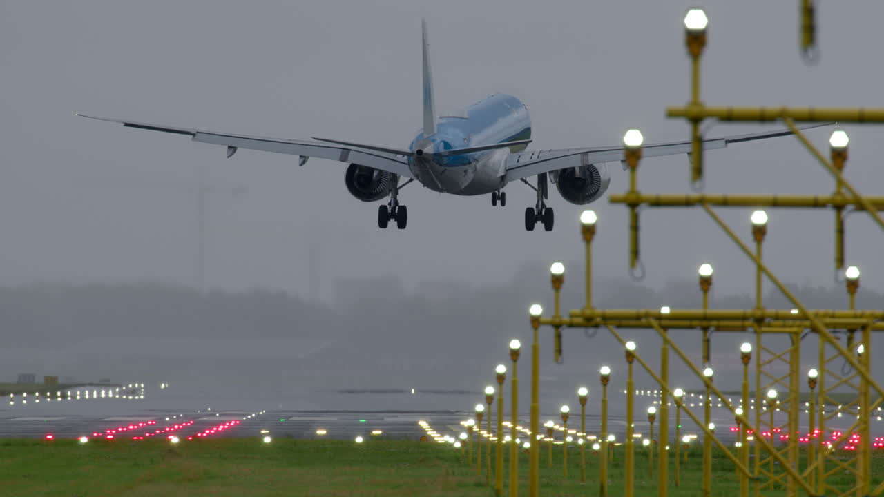 비와 안개 속에서 비행기가 착륙하는 것