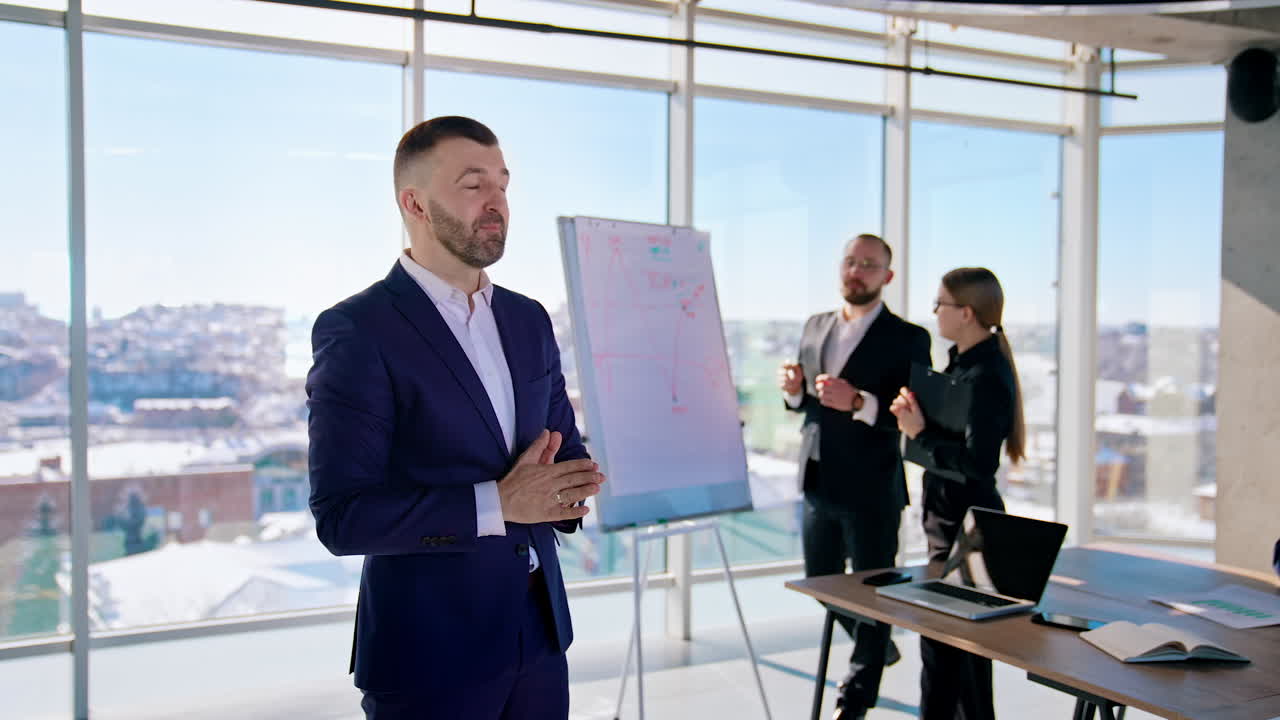 Portrait of executive man in office center. Business people working at new blueprint on the window city background. Handsome businessman in suit talking on camera.