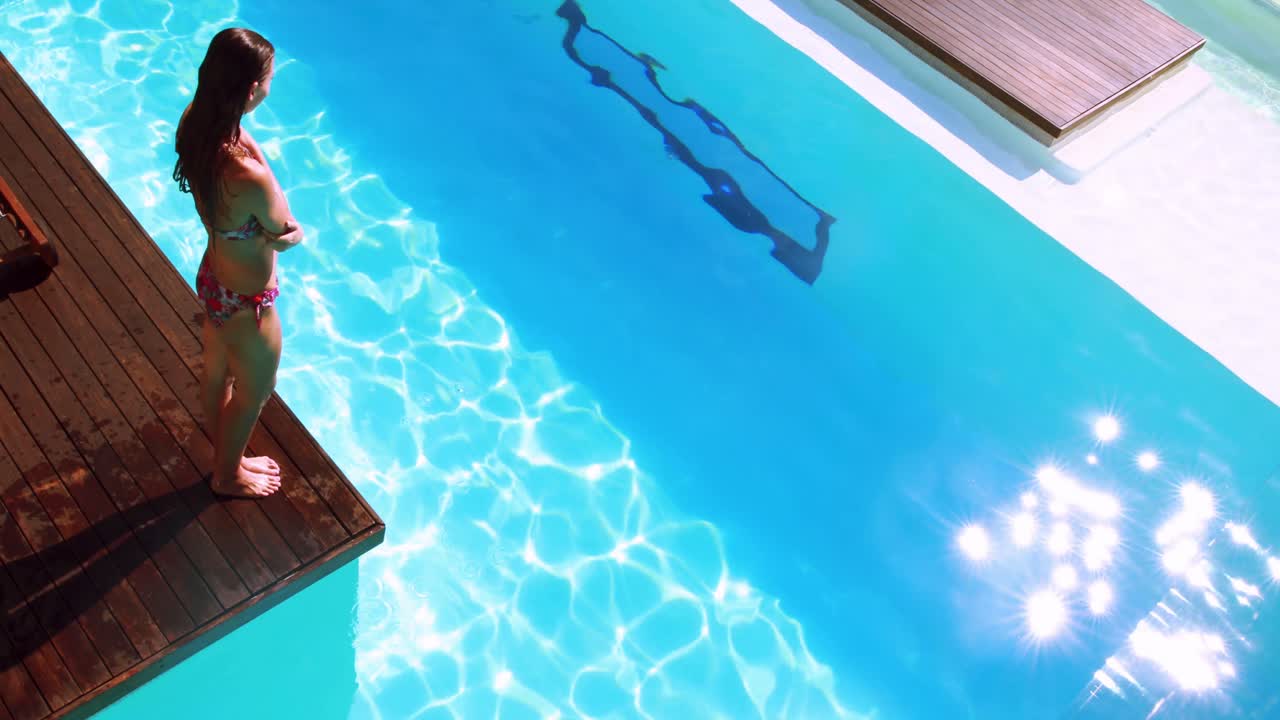 Brünette taucht in klaren blauen Pool