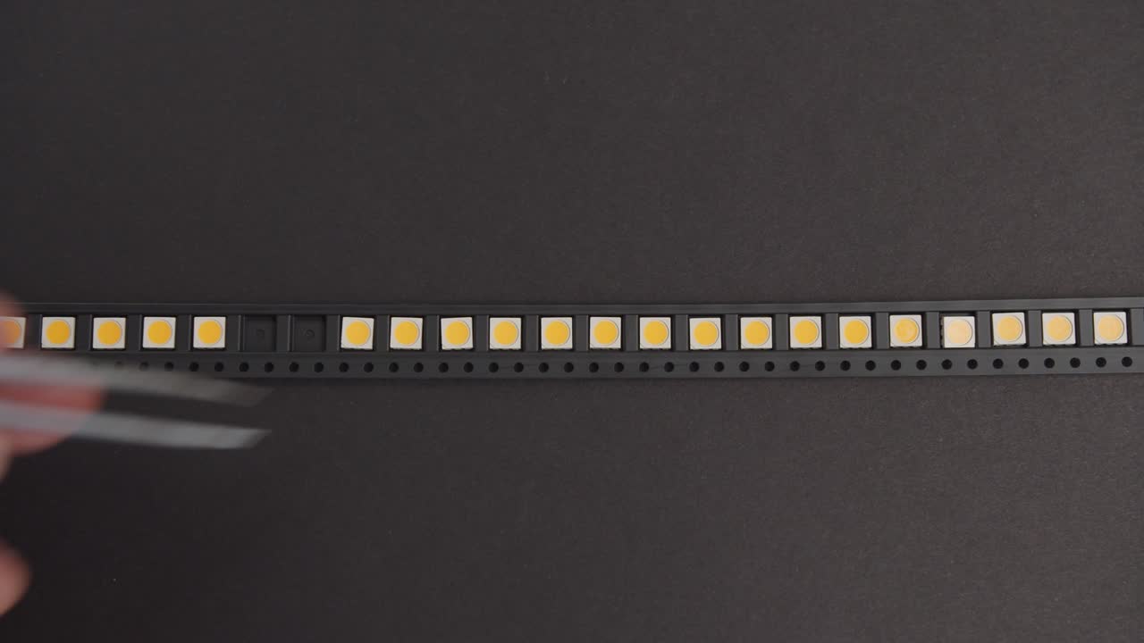 recoger manualmente componentes electrónicos con pinzas vista superior