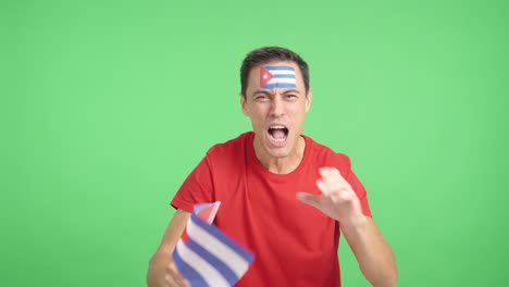 man cheering for cuba screaming and waving a national flag
